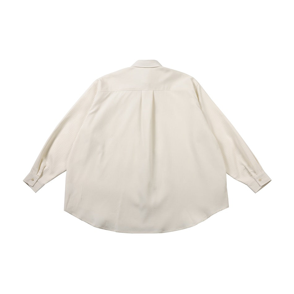 Back view of an ivory long-sleeve button-up shirt with a center pleat and curved hem, laid flat on white.