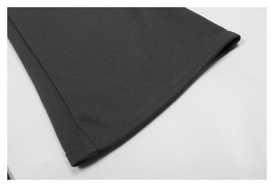 Close-up of the double-stitched hem on charcoal pants.