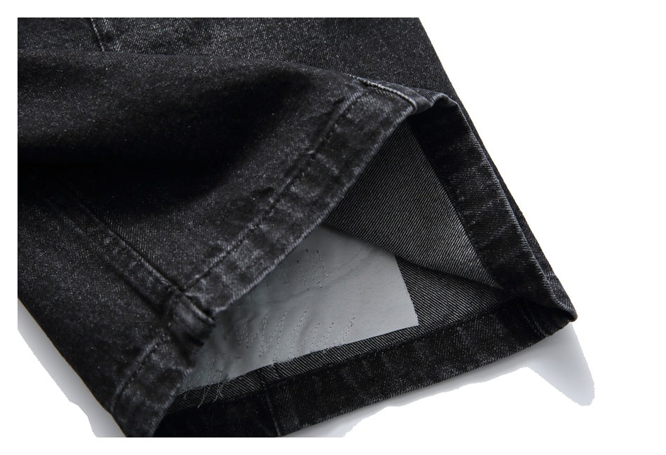 Close-up of a black denim shorts leg hem turned back to reveal the inside fabric and seam.