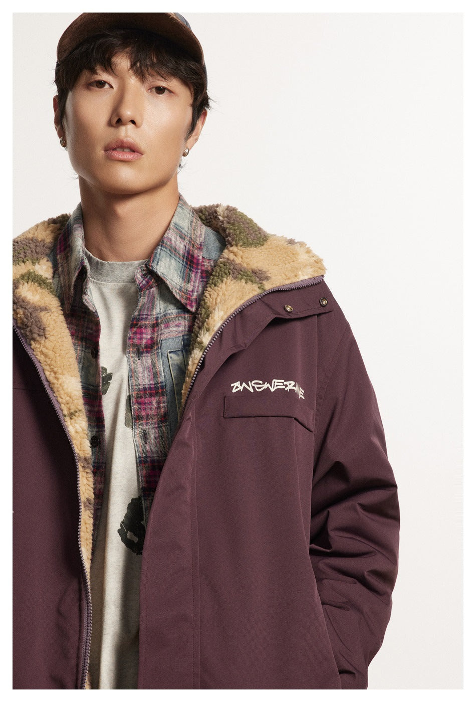Close view of a model wearing a burgundy jacket with a camouflage fleece collar and chest pocket.