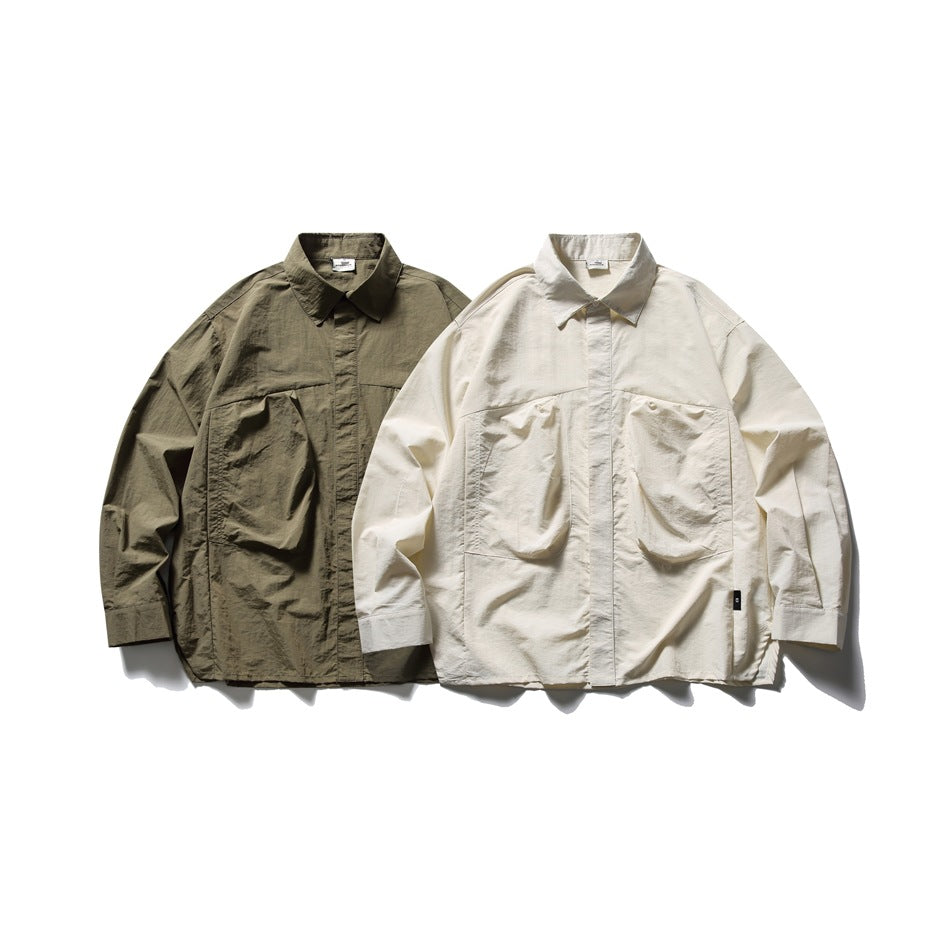 Two oversized button-up shirts shown flat: one dark olive and one ivory, each with two large front pockets.