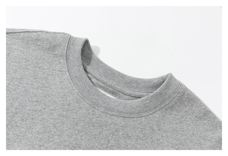 Close-up of a gray sweatshirt's ribbed crew neckline and shoulder seam on a white background.