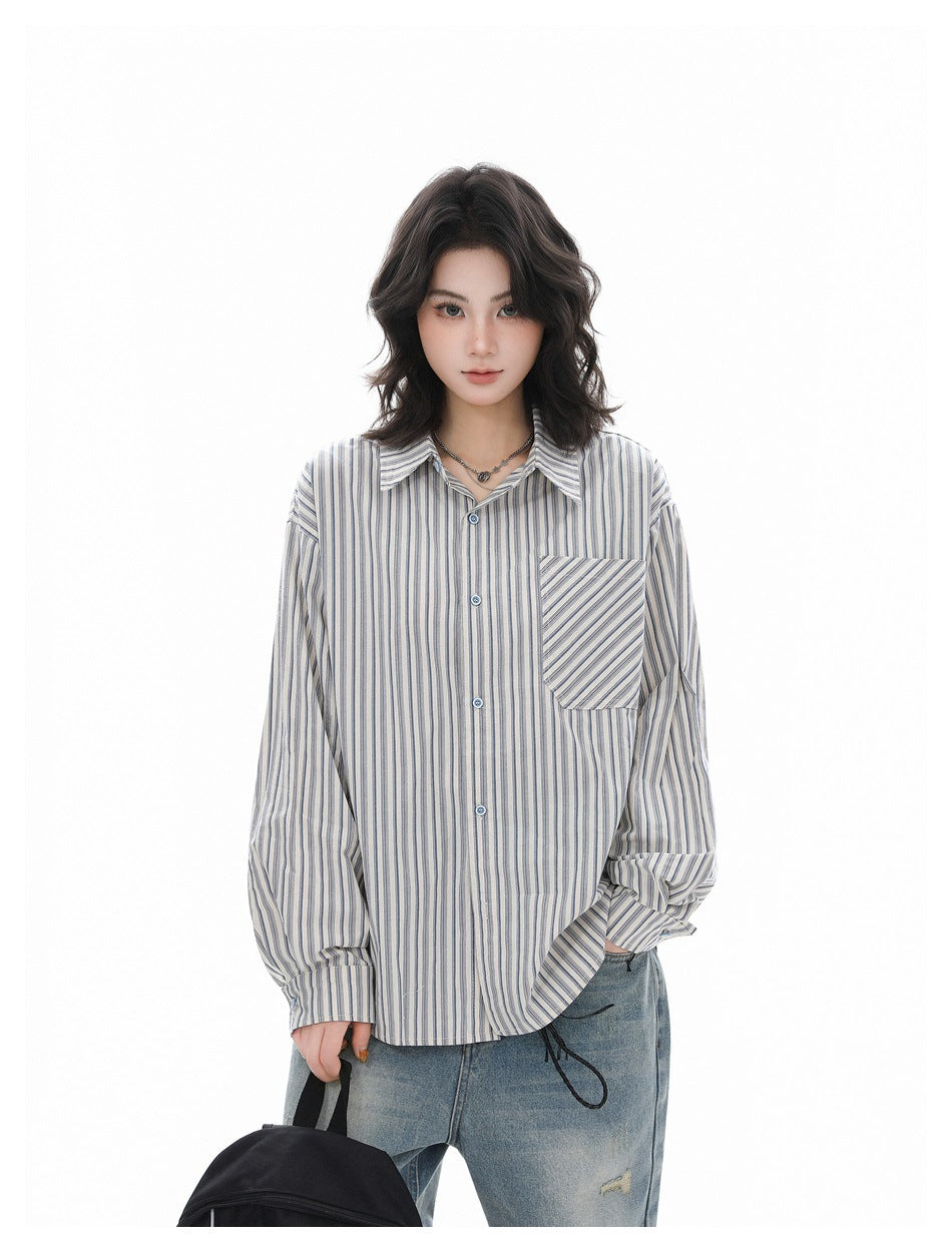 Person wearing an oversized blue striped button-up shirt with light jeans, holding a black bag