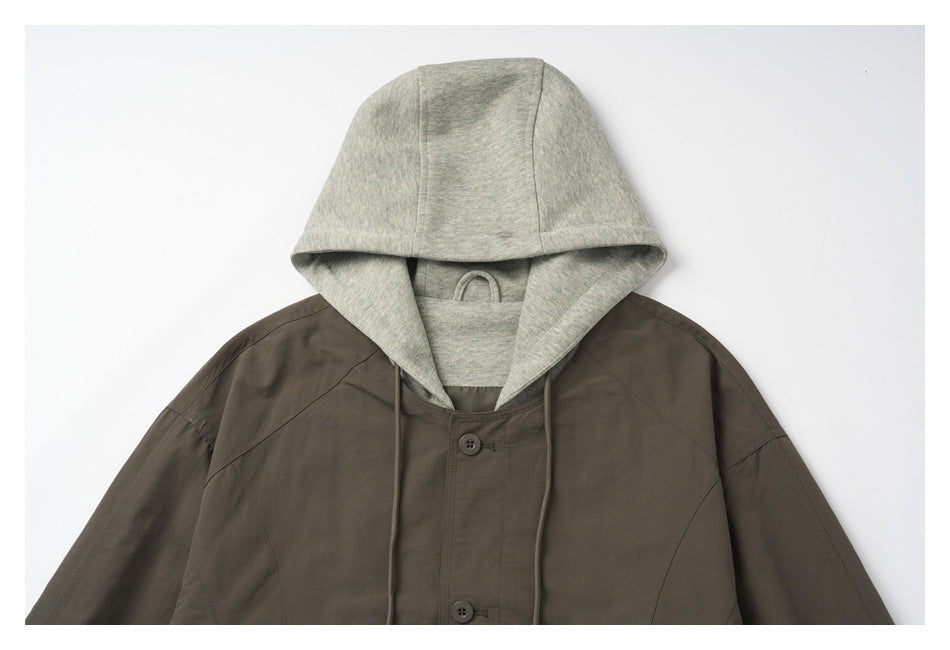 Close-up of the jacket's light gray hood, drawstrings, and buttoned front in dark brown.