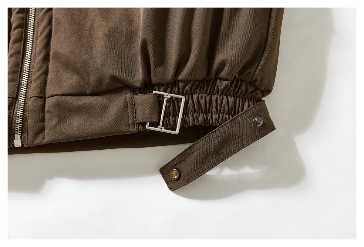 Close-up of the brown jacket’s gathered waist and adjustable snap-fastened tab.