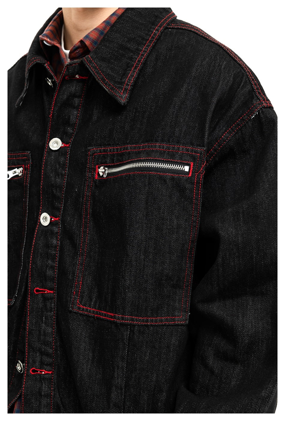 Close-up of the black jacket's red stitching, pointed collar, silver buttons, and zippered chest pocket.