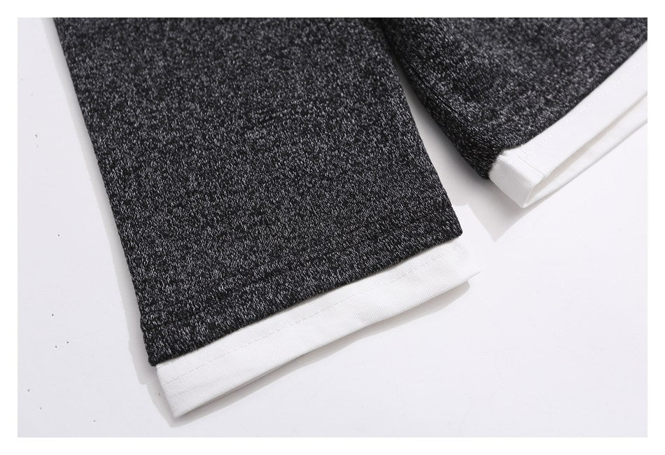 Close-up of charcoal marled sleeves with wide white cuff trim.