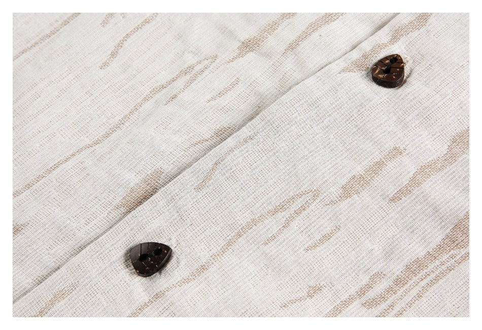 Close-up of two dark buttons on the ivory jacket's tan patterned fabric.