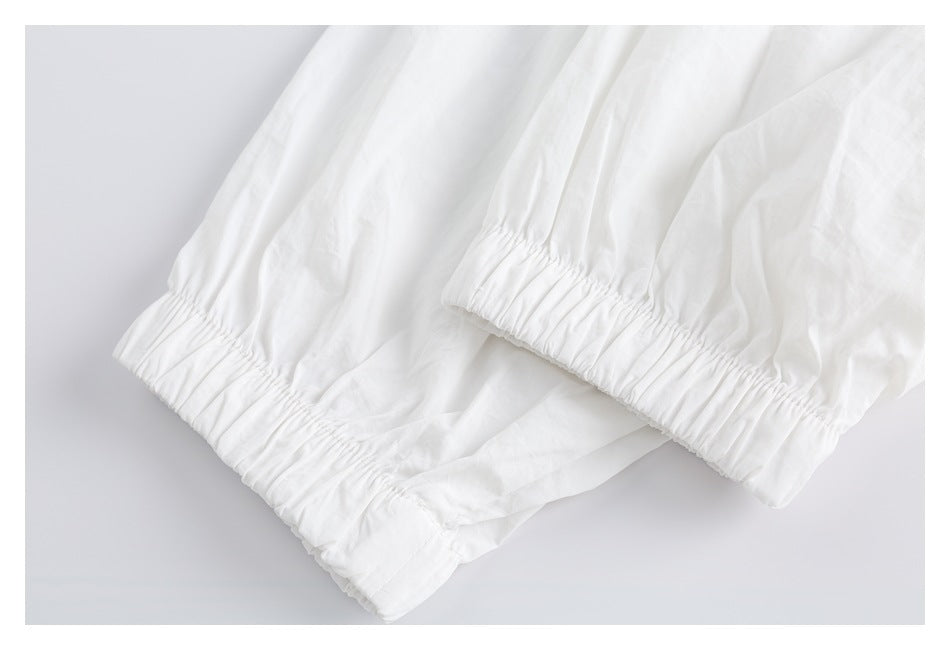 Close-up of gathered elastic cuffs on a white garment.