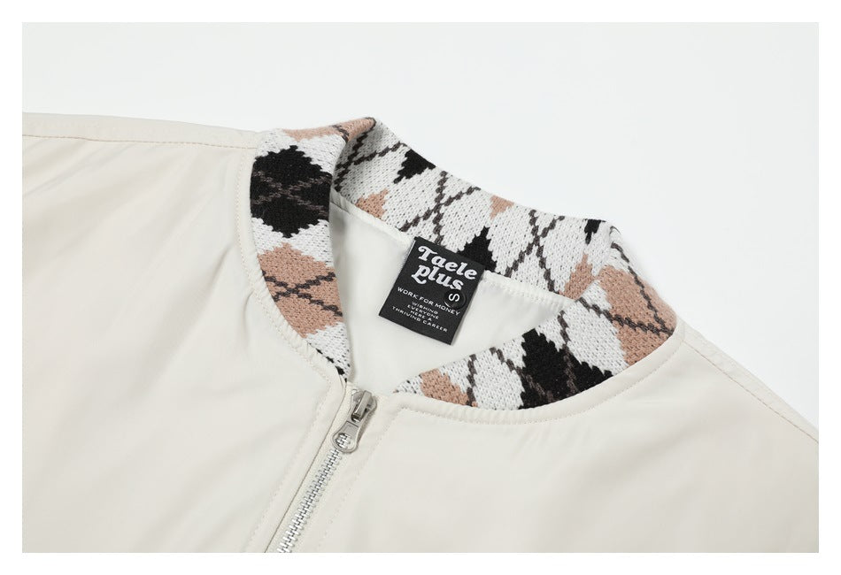 Close-up of an ivory jacket collar with a black, white, and tan patterned knit lining, zipper, and sewn-in label.