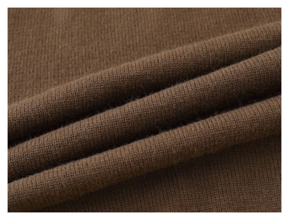 Close-up of brown knit fabric arranged in soft folds, showing its looped texture.
