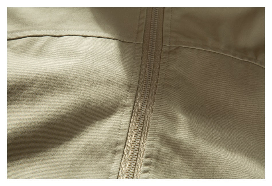 Close-up of a beige garment's vertical zipper and stitched panel seams.