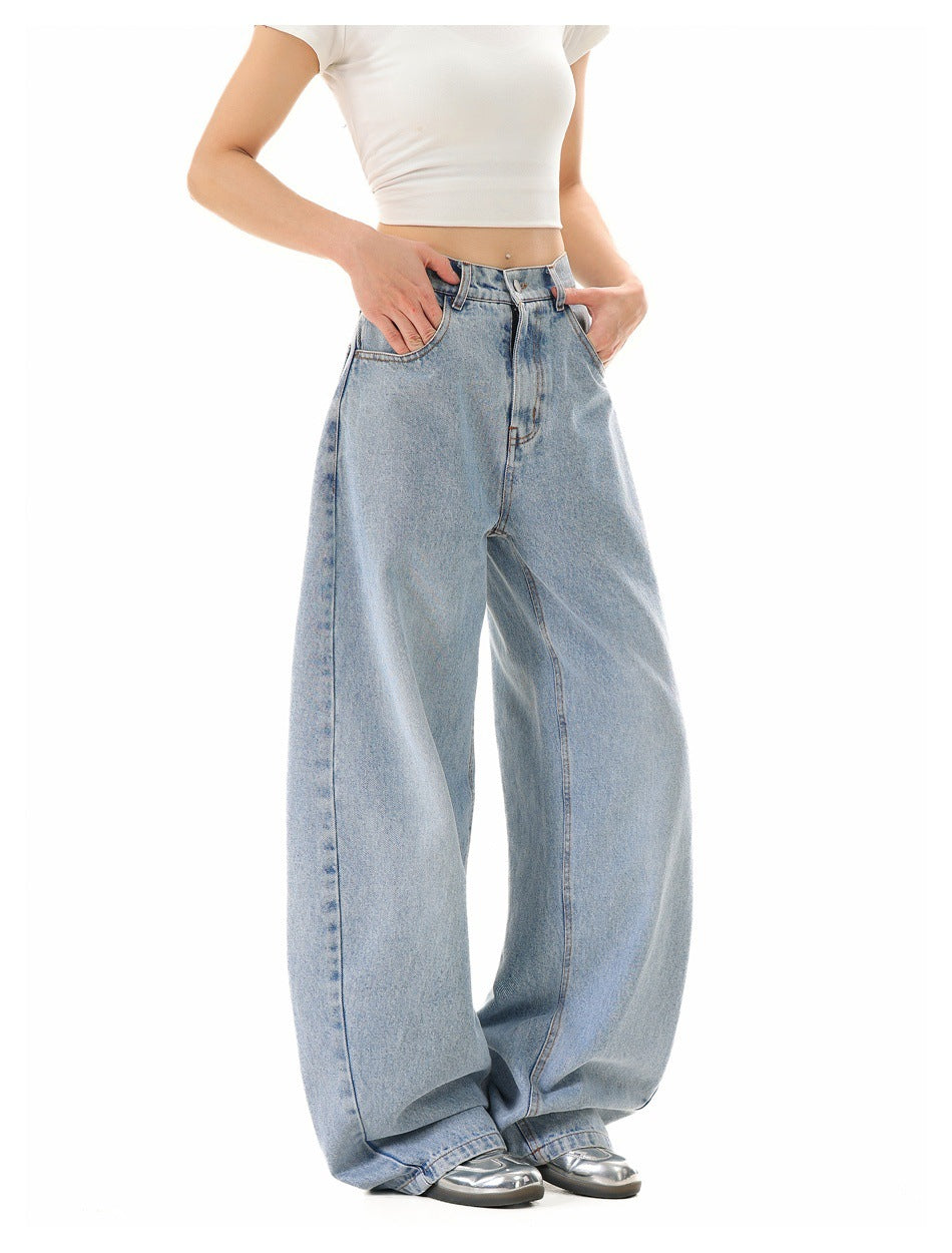 Model wearing light-wash, very wide-leg jeans with a white cropped T-shirt, front three-quarter view.
