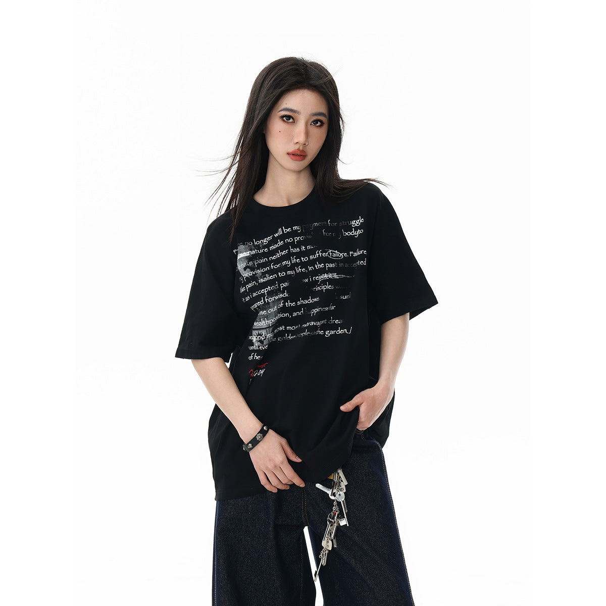 Model wearing an oversized black graphic T-shirt with dark wide-leg jeans, shown from the front.