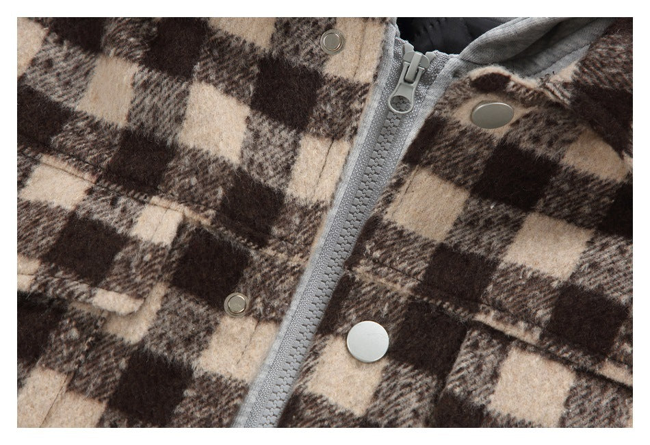 Close-up of the jacket's gray zipper, metal snaps and brown and beige checked fabric.