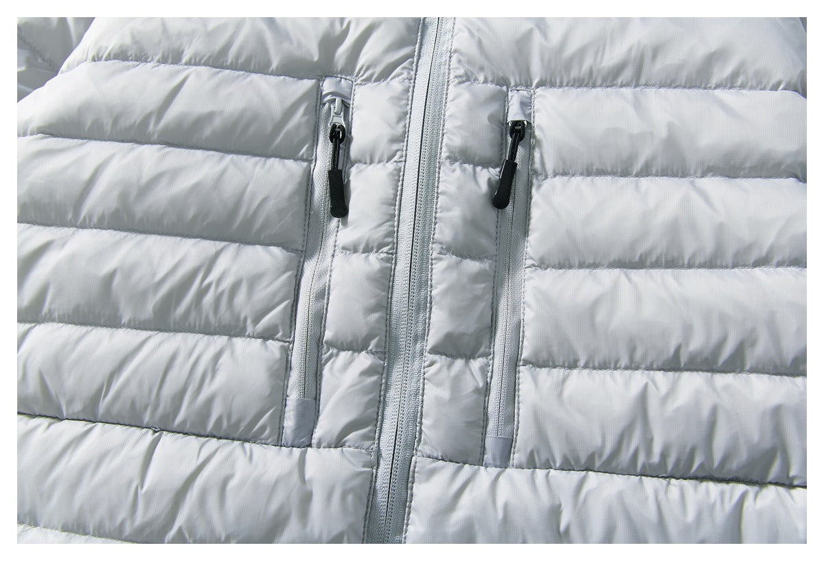 Close-up of a light gray quilted jacket front with a central zipper and two vertical zip pockets.