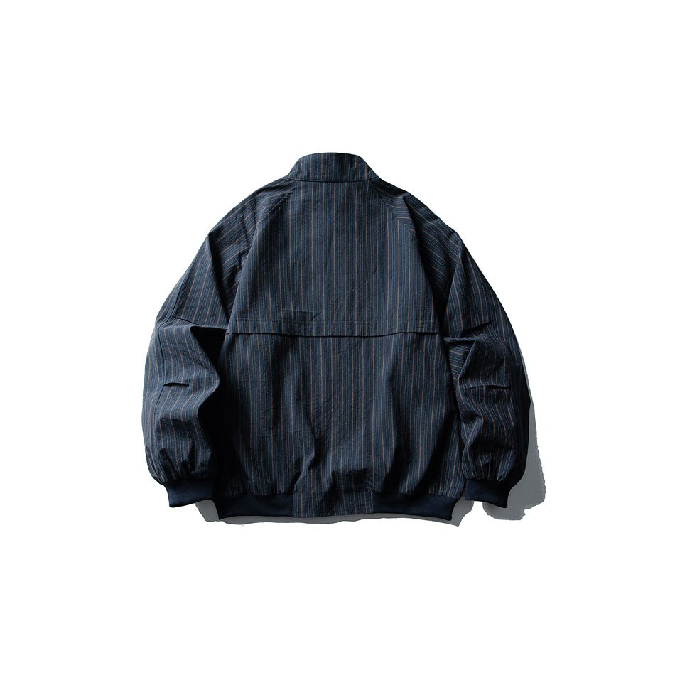 Back view of a dark blue pinstriped jacket with a stand collar, rear yoke, and elastic cuffs and hem.