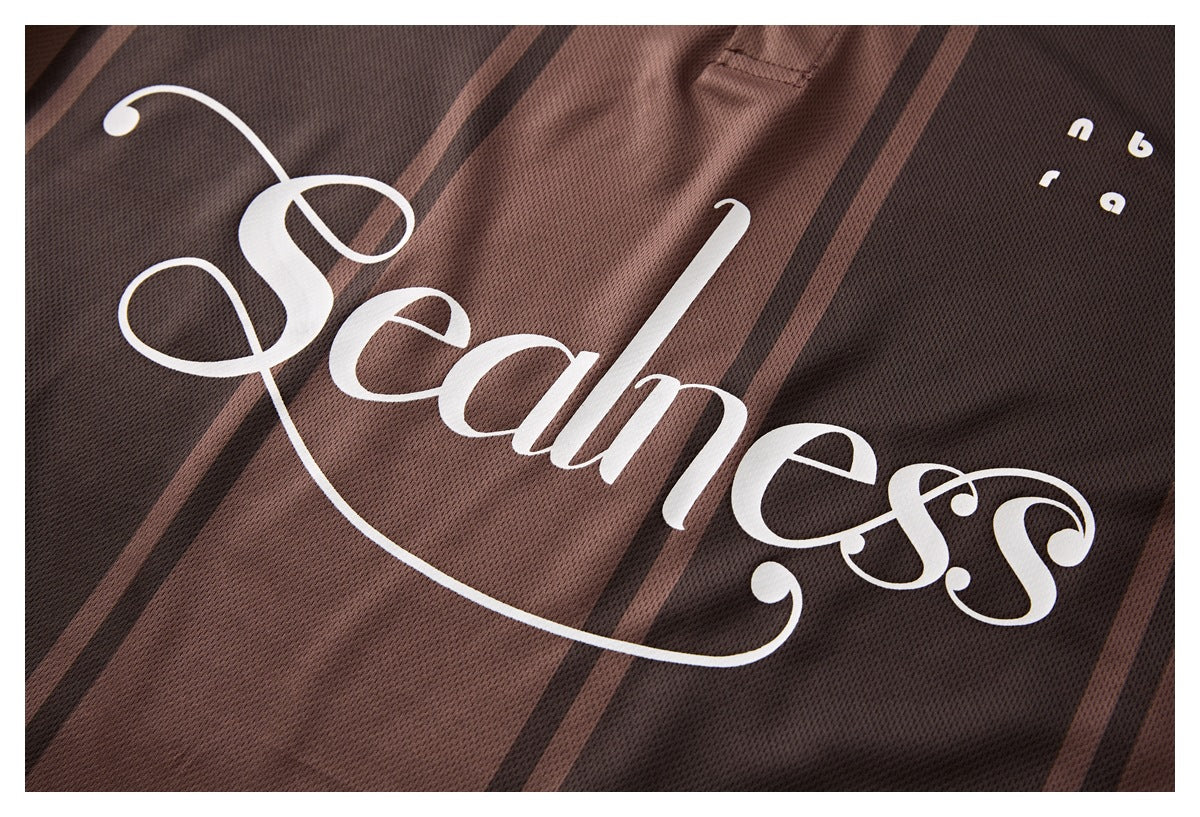 Close-up of a brown striped mesh polo showing large white “Seamless” lettering.