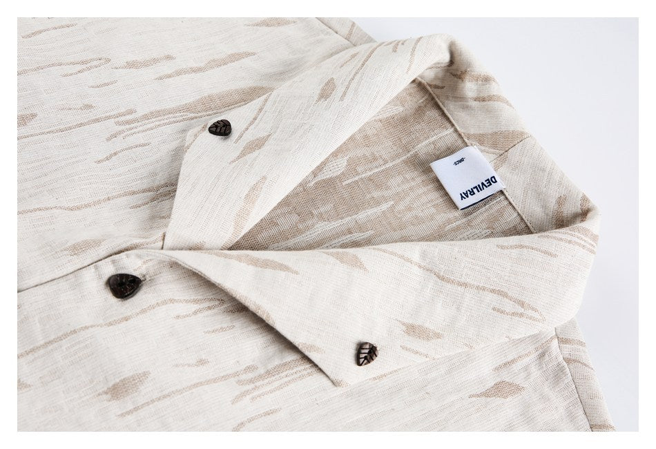 Close-up of the ivory jacket's notched lapel, tan abstract pattern, dark buttons, and sewn inner label.