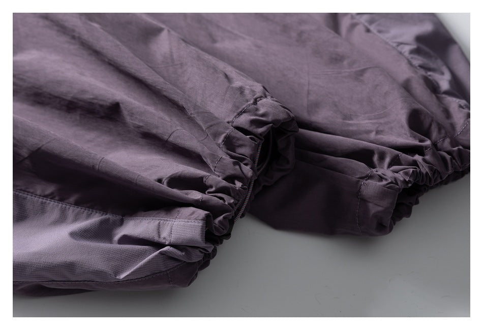 Close-up of the mauve-gray pants' gathered elastic leg opening and drawcord detail.