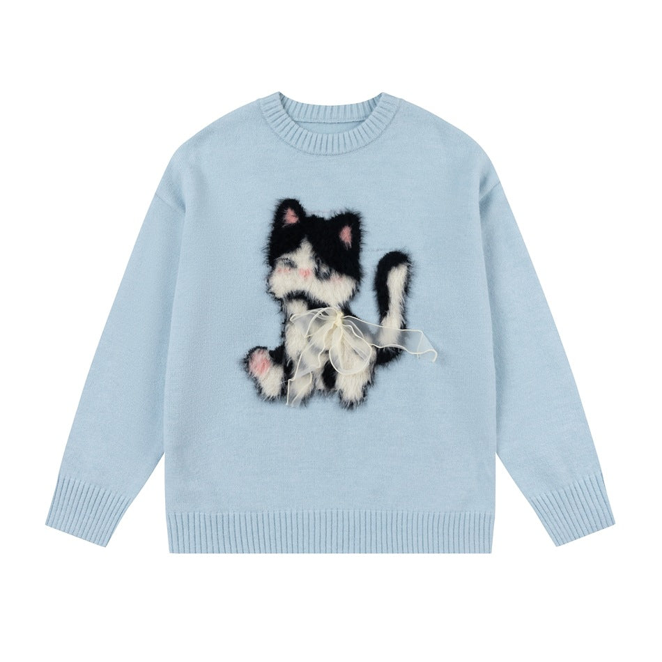 Light blue crew-neck knit sweater with fuzzy black and white cat motif and sheer ribbon bow, flat front view