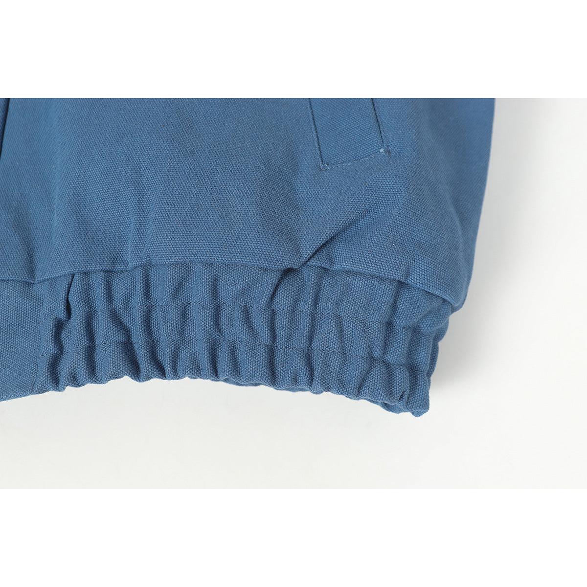 Close-up of the gathered elastic hem on a blue jacket.
