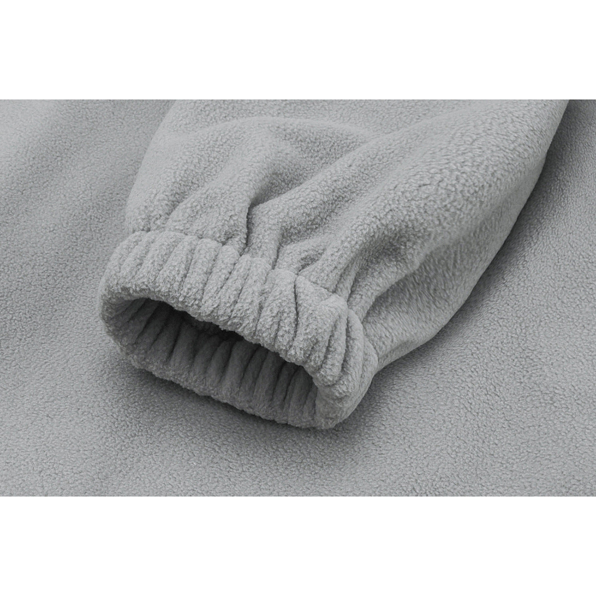 Close-up of a light gray fleece sleeve gathered into a ribbed elastic cuff.