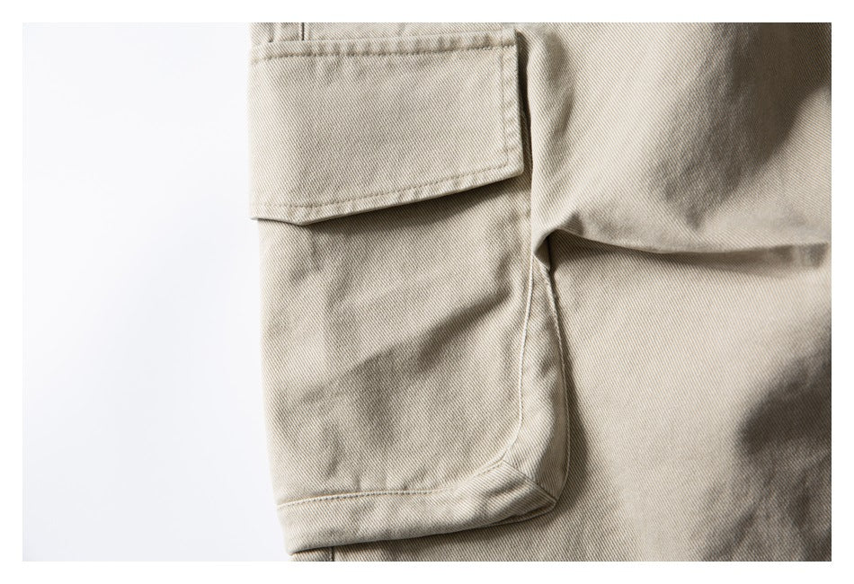 Close-up of a large flap cargo pocket on beige shorts.