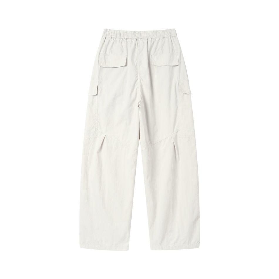 Back view of beige wide-leg cargo pants showing two flap back pockets, elastic waist and side cargo pockets