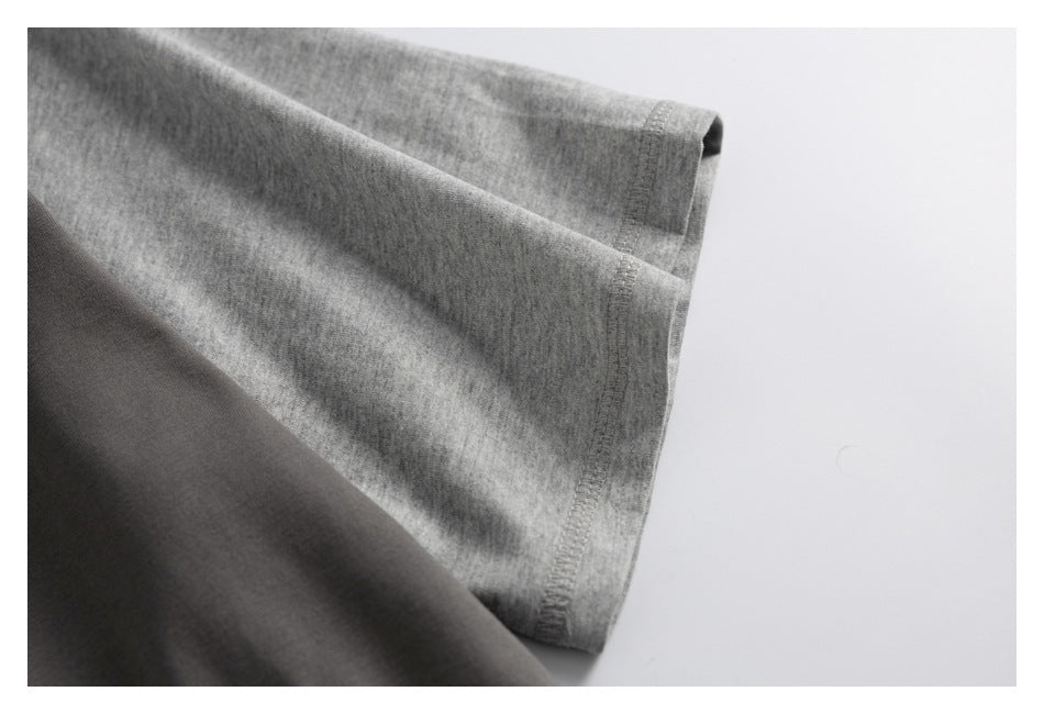 Close-up of a heather-gray sleeve cuff beside the dark charcoal garment body, showing the stitched edge.