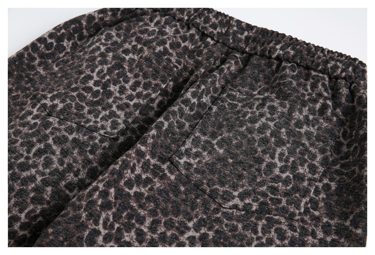 Close-up of dark leopard-print garment with a gathered waistband and two rectangular pockets.