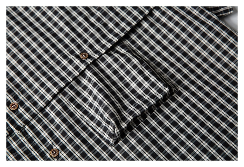 Close-up of a black-and-white checked shirt showing its button placket and chest pocket.