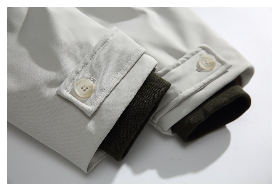 Close-up of white jacket cuffs with buttons and dark ribbed inner cuffs.