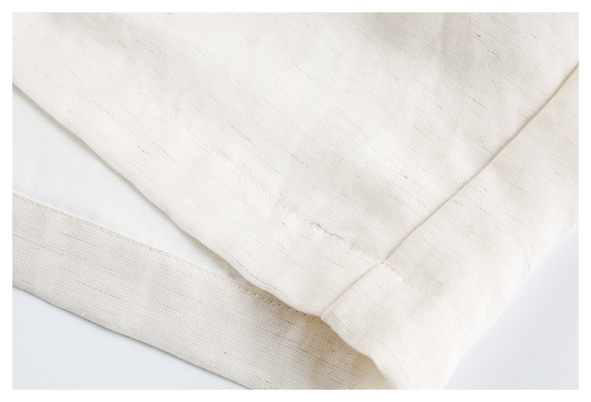 Close-up of cream fabric with a folded, stitched hem.