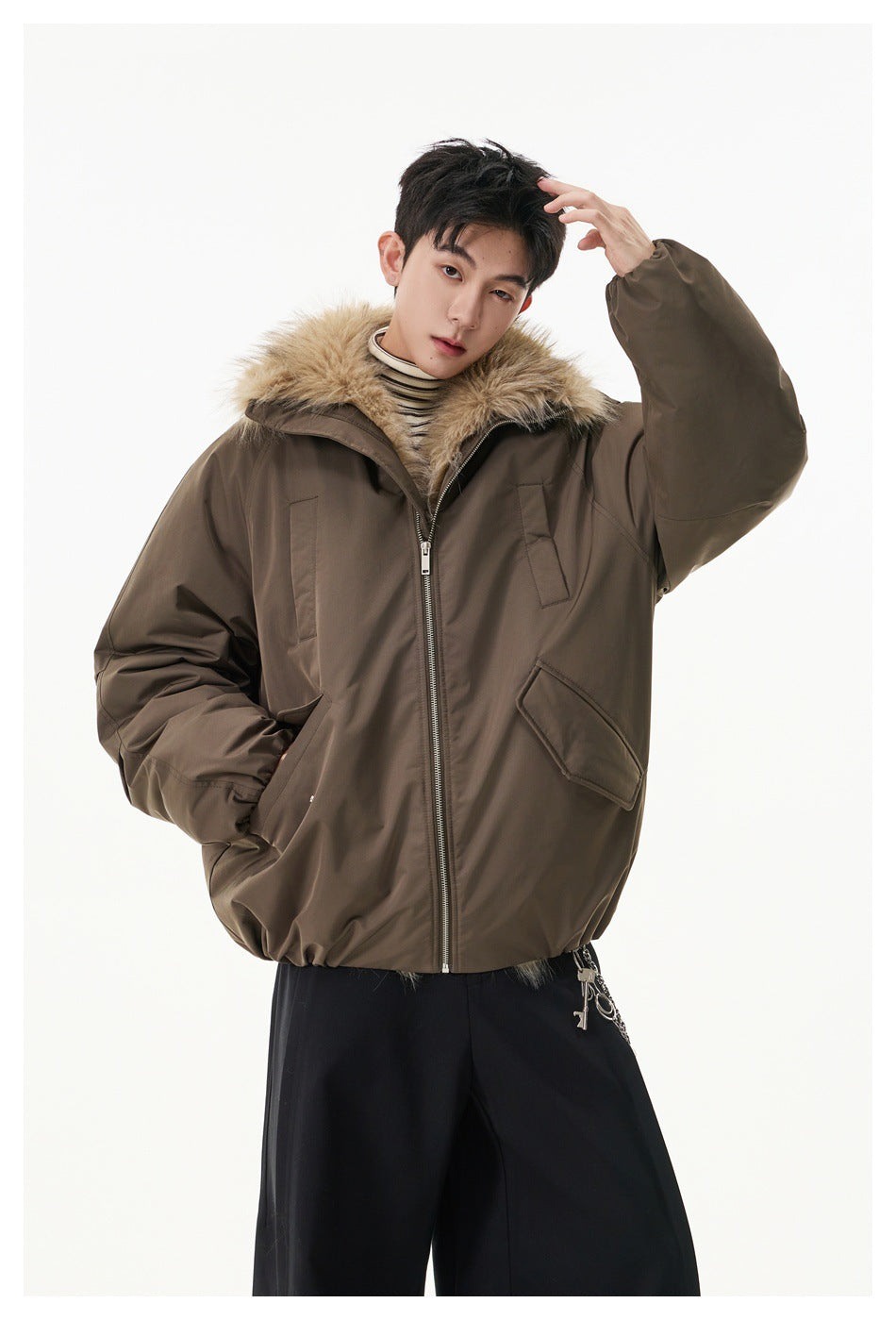 Model wearing an oversized brown zip jacket with fluffy collar and flap pockets over black wide-leg pants