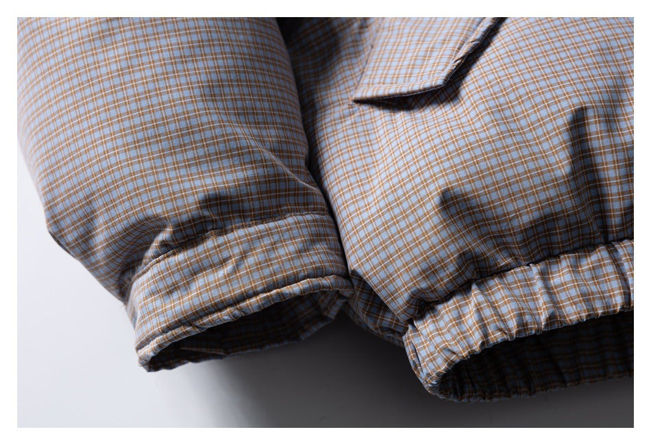 Close-up of a blue and tan checked jacket sleeve cuff and gathered hem.