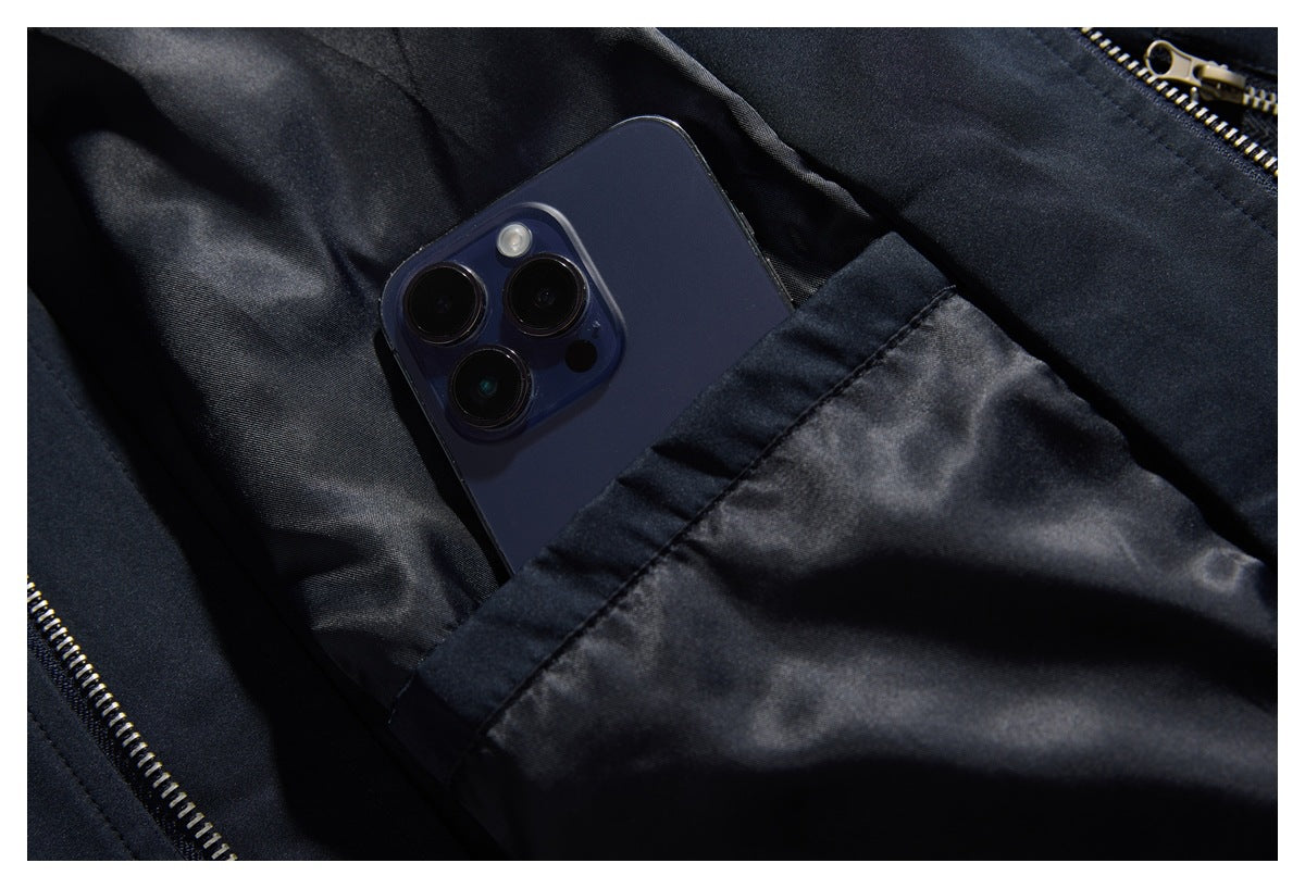 Close-up of the dark jacket's shiny inner lining and pocket holding a smartphone.