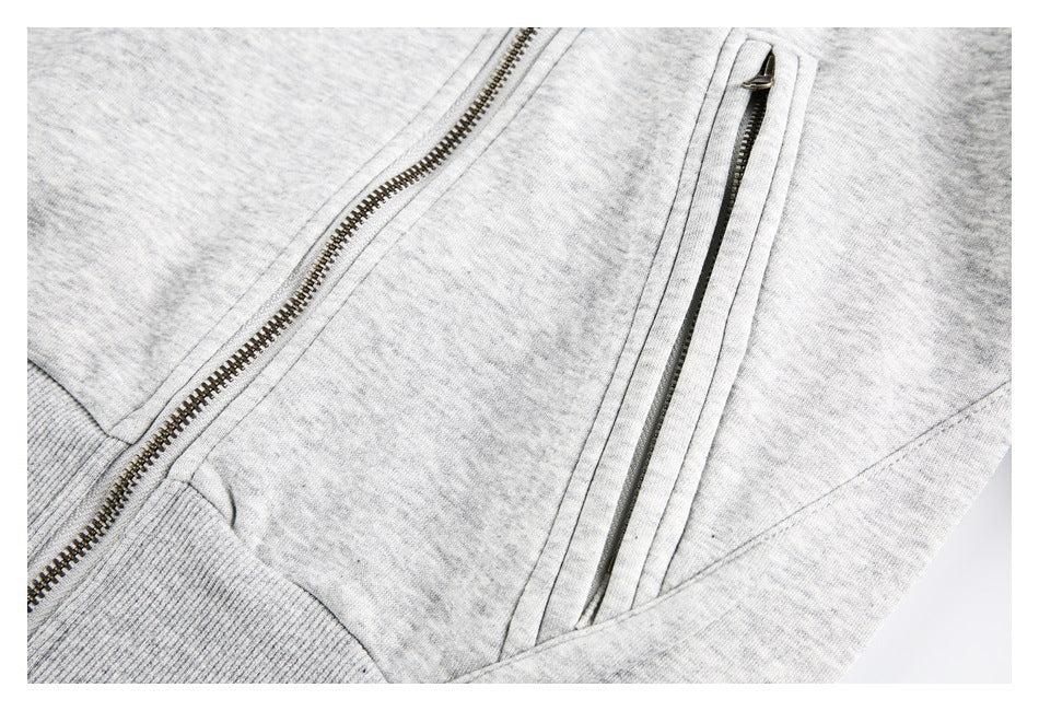 Close-up of a diagonal zip pocket and front zipper on a light gray jacket.