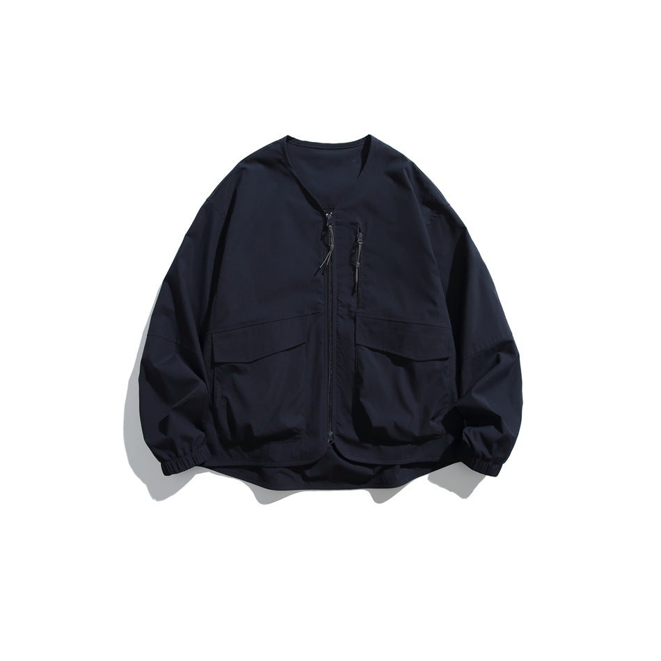 Navy collarless zip jacket with two large flap pockets and elastic cuffs, flat lay front view