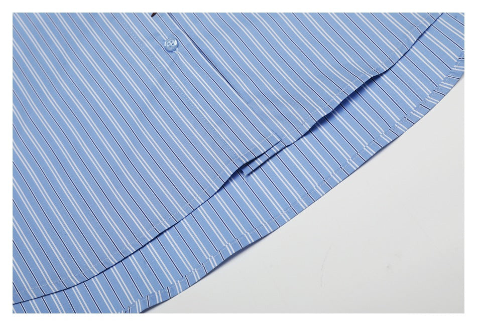 Close-up of the curved hem and double stitching on the blue striped shirt.