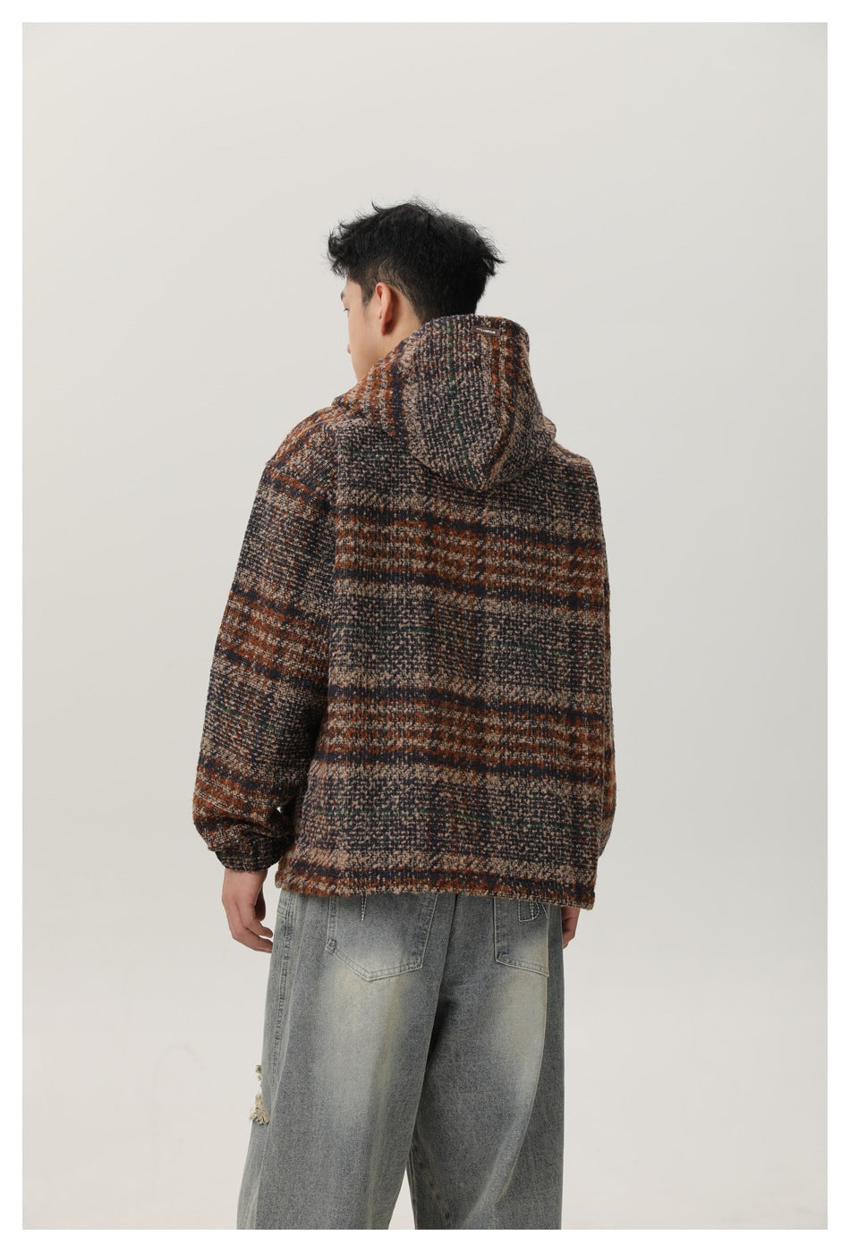 Rear view of a man showing the hood and striped back of a brown, charcoal and beige pullover.