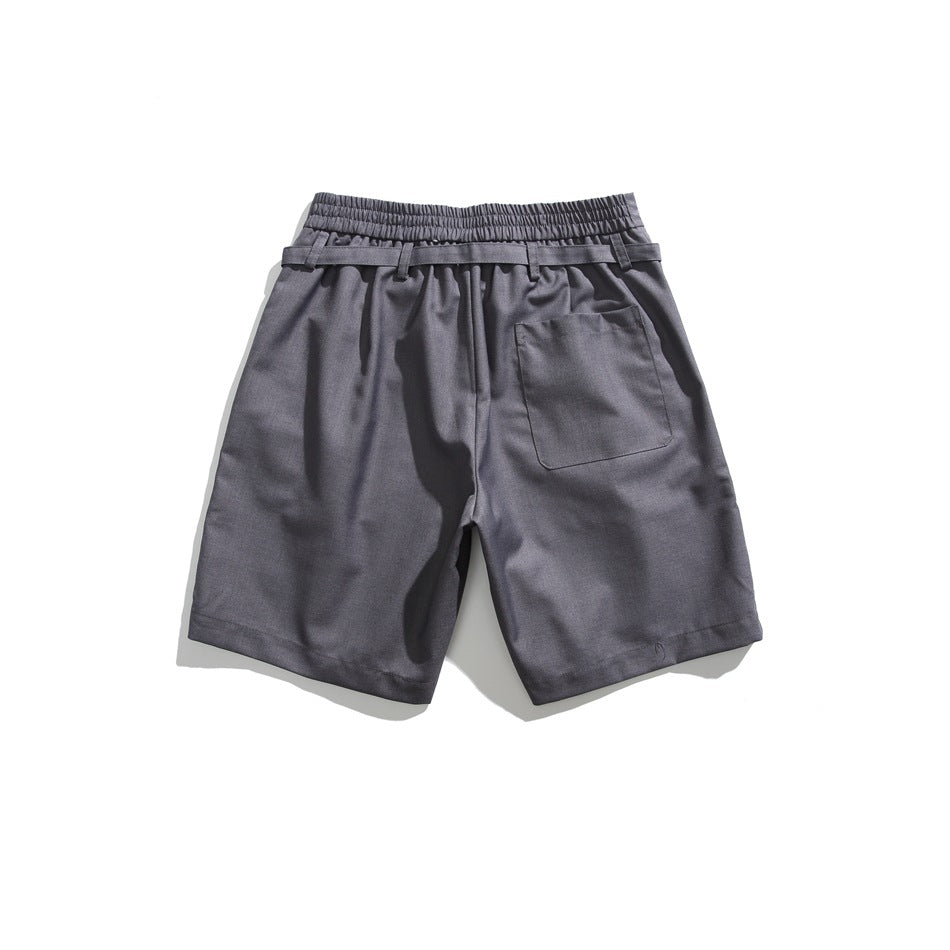 Back view of gray shorts with an elastic waistband, belt loops, and a single patch pocket.
