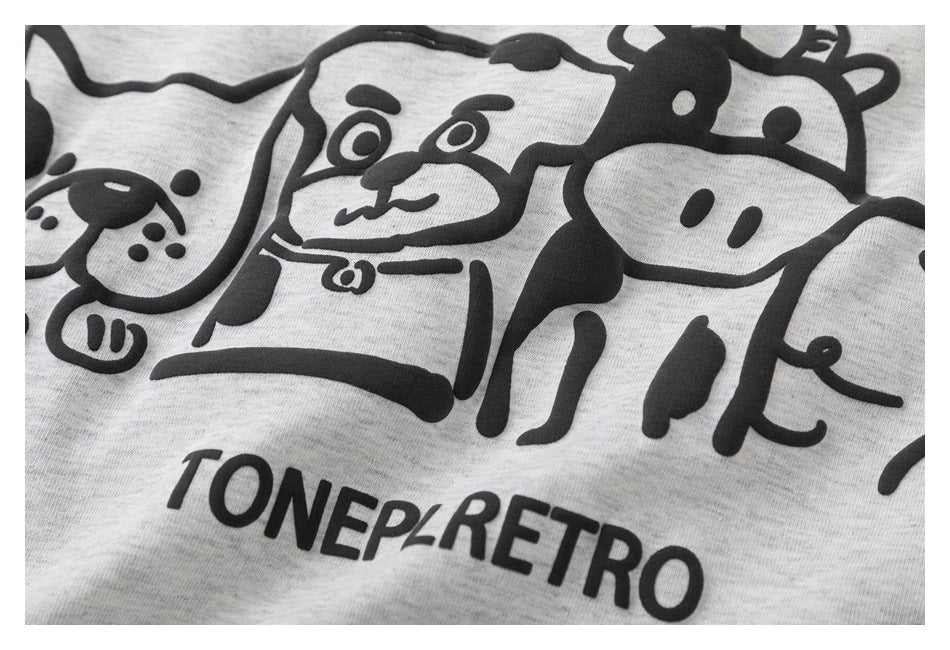 Close-up of the black cartoon animal print and lettering on light gray heather fabric.