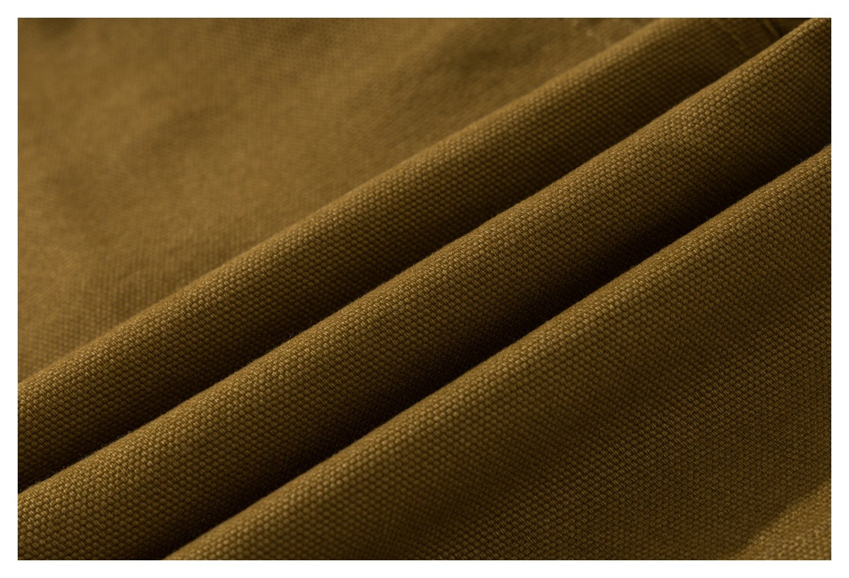 Extreme close-up of the mustard-brown shorts' textured woven fabric.