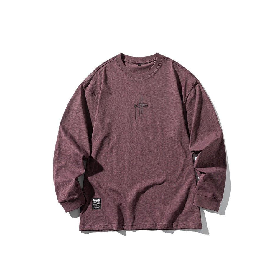 Muted purple long-sleeve crew-neck top flat lay with dark chest lettering and hem label