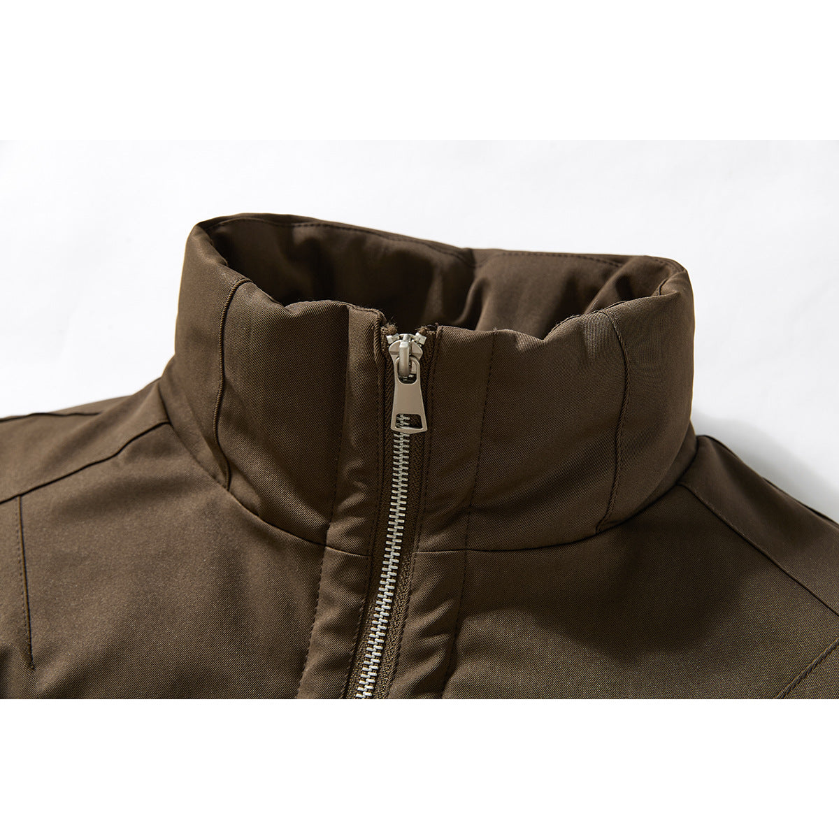 Close-up of a dark brown jacket's tall stand collar and silver center zipper.