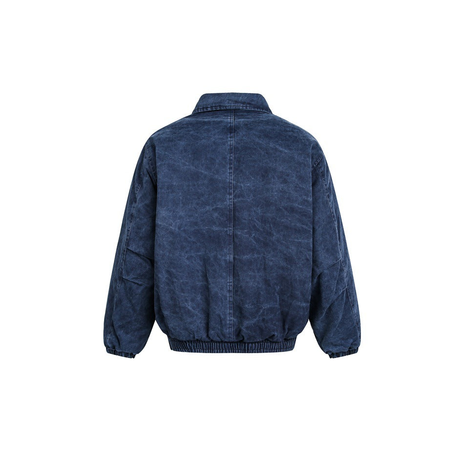 Back view of a dark indigo jacket with a pointed collar, center seam, and elasticated hem and cuffs.