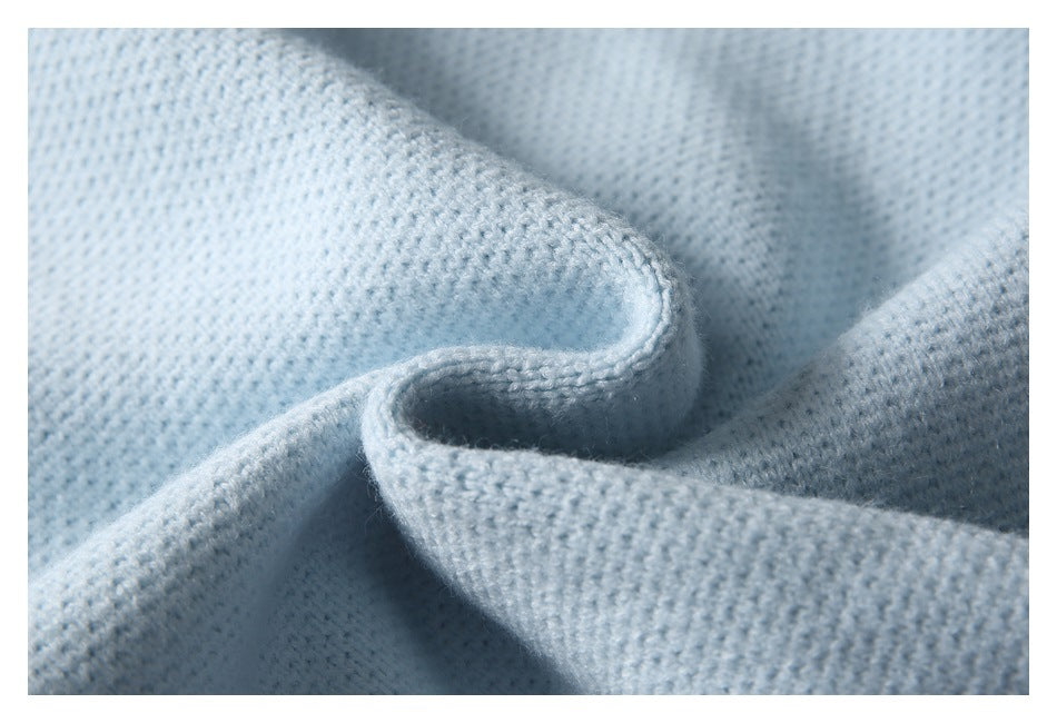 Close-up of pale blue knit fabric folded to show its textured surface.