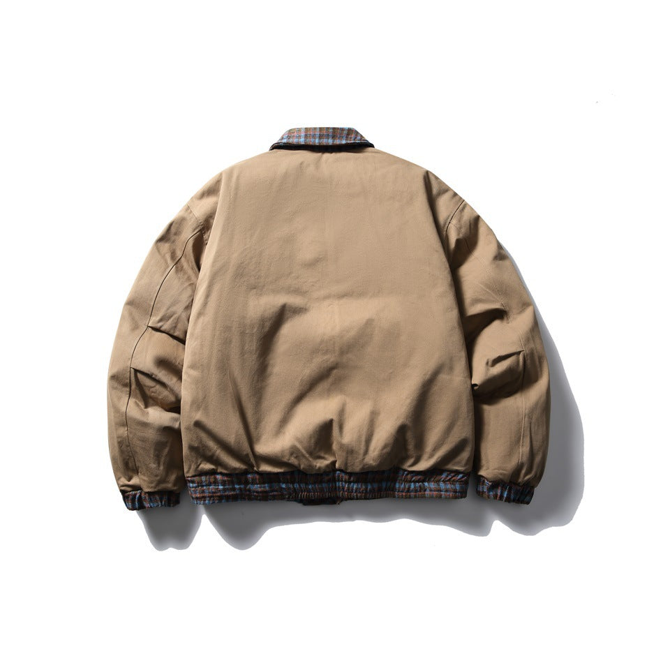 Back view of a tan jacket laid flat, with plaid collar, cuffs, and hem trim.