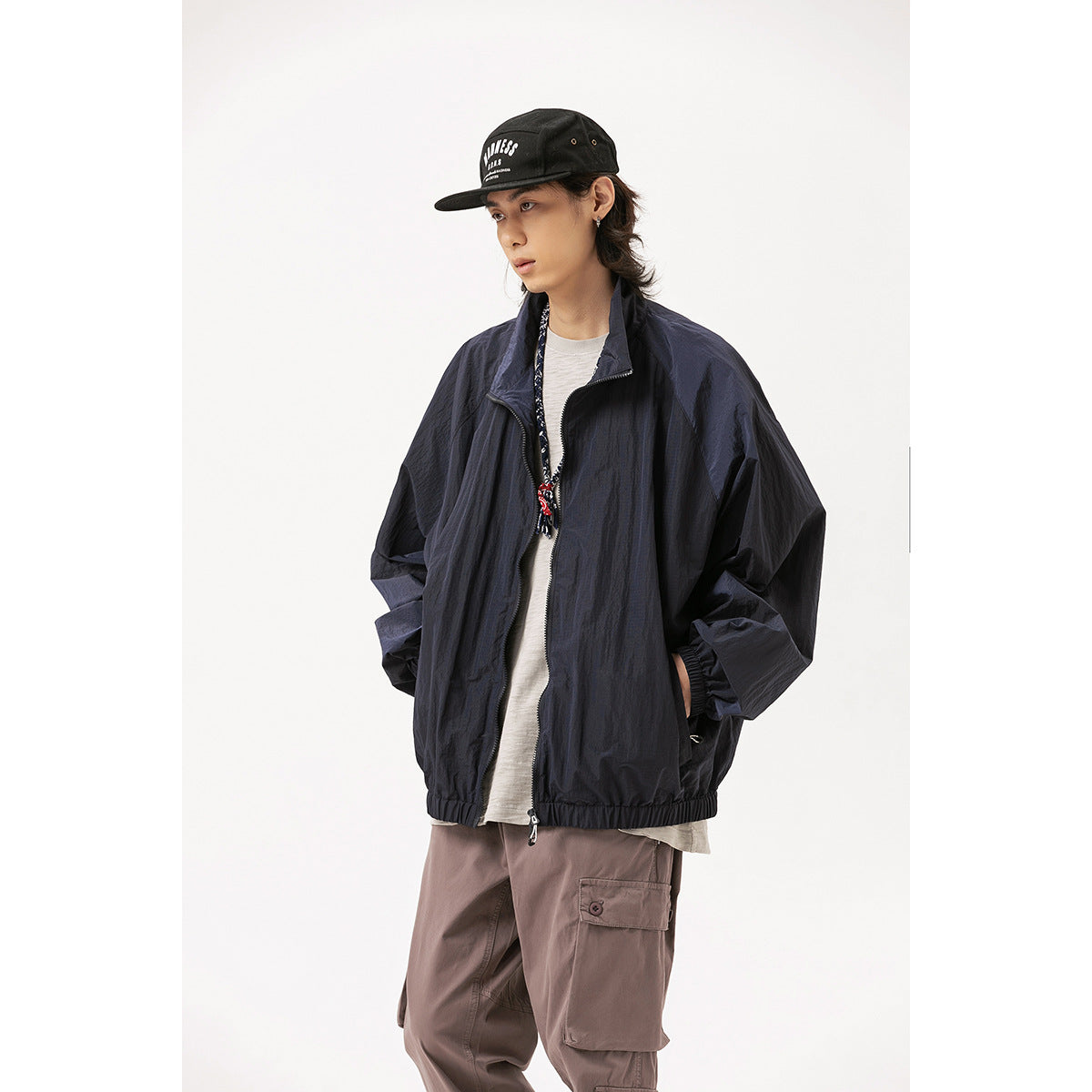 Model wearing an oversized dark navy zip-front jacket with a high collar, elastic cuffs and hem.